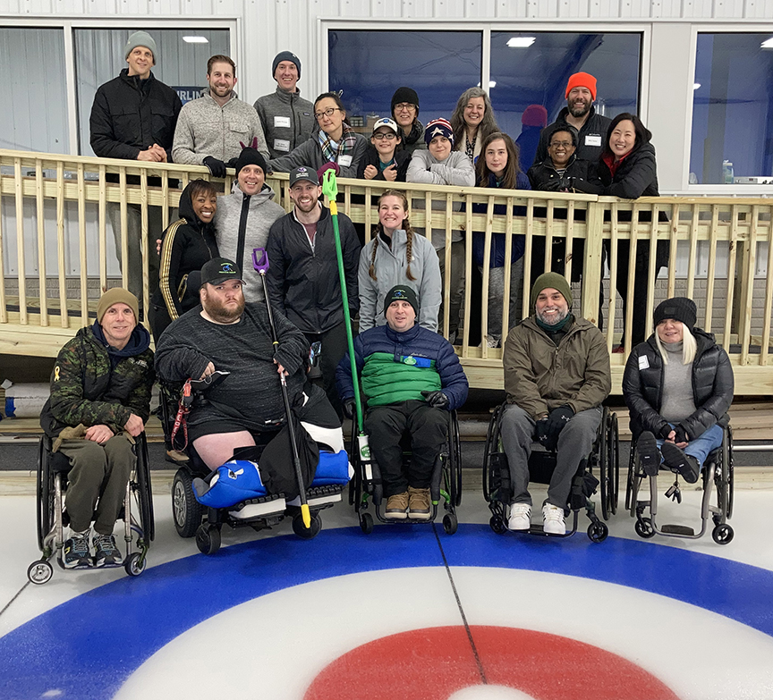 Group of men and women on the ice after a curling event