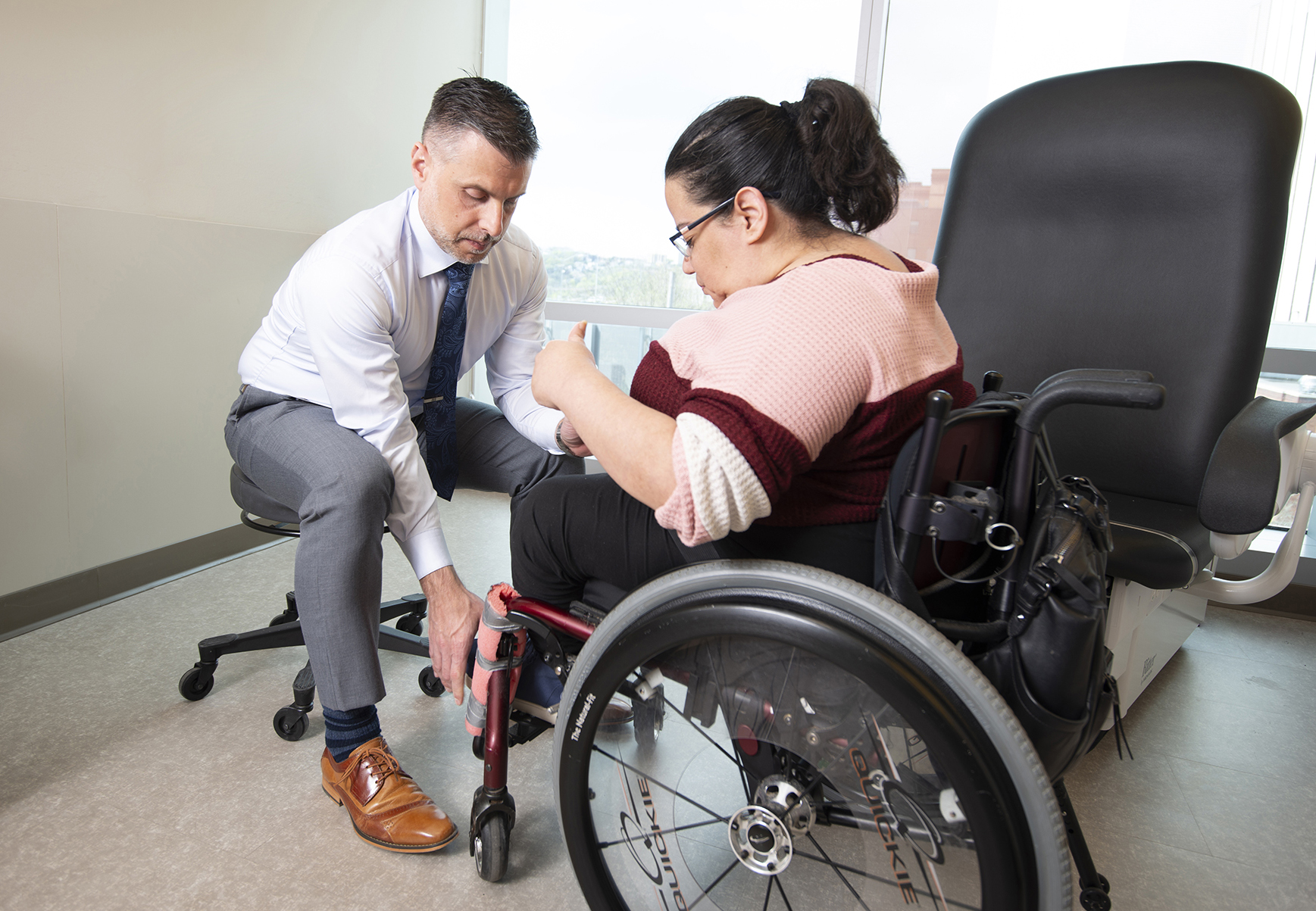 Physician assiting patient with her wheelchair
