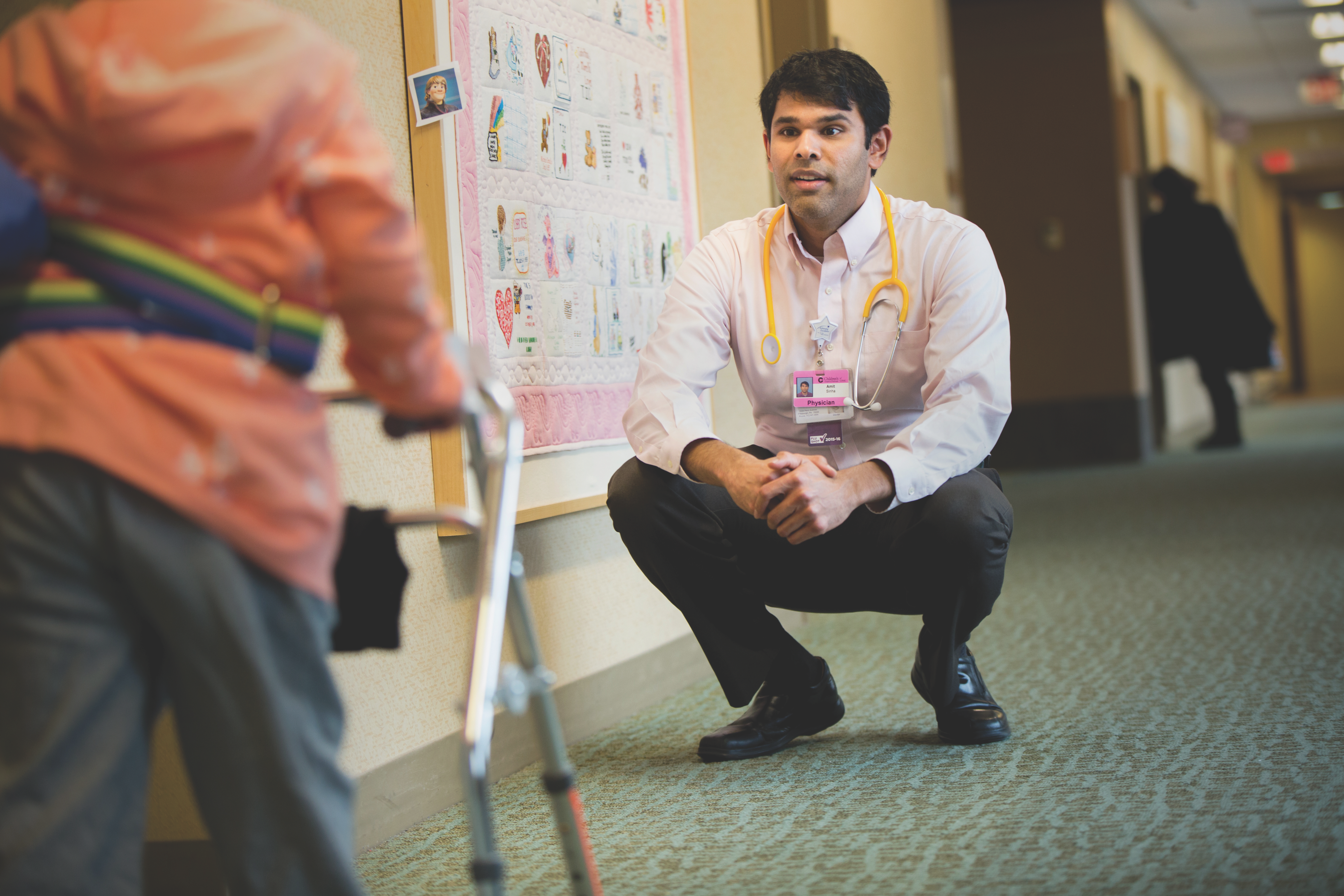 Physician assesing a child with an assitive device to help walking