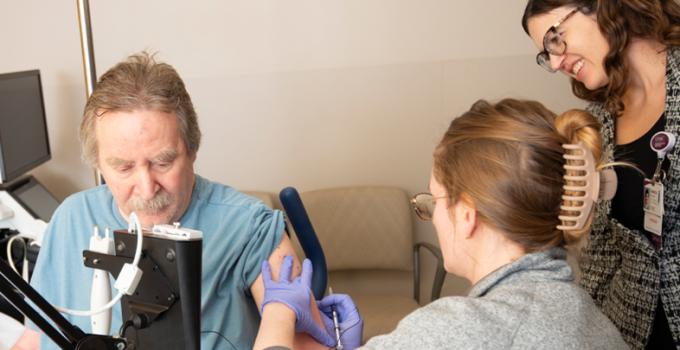 Fellow administering an injection with an attending physician looking on