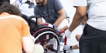 people working on tuning up a wheelchair