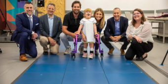 group of research scientists and a family kneeling for a photo in the RNEL laboratory